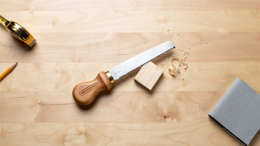 Mini Hand Saw for Wood cutting a small wooden board with a precise hand cut.
