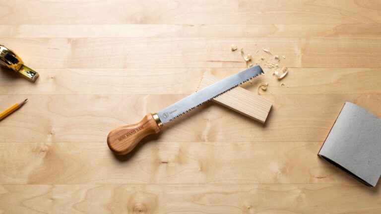 Mini Hand Saw for Wood cutting a small wooden board with a precise hand cut.